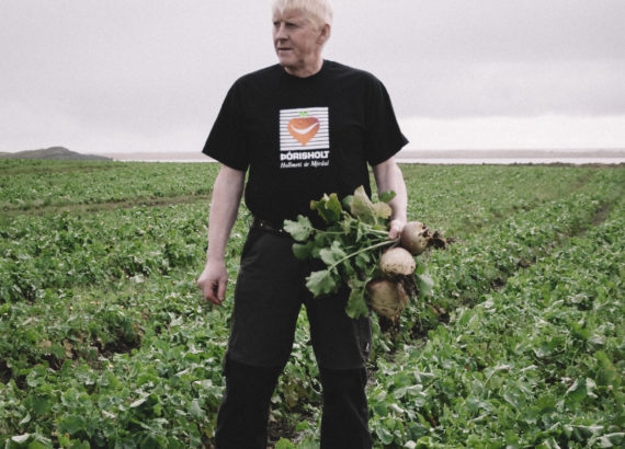 Guðni on a field with turnips in his hands